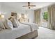 Bright bedroom with a comfortable bed, soft lighting, white walls and window with decorative curtains at 7906 Skye Lochs Dr, Waxhaw, NC 28173