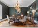 Elegant dining room features a chandelier, a dark accent wall, and a wooden table at 7906 Skye Lochs Dr, Waxhaw, NC 28173