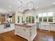 Bright kitchen featuring a central island, white cabinetry, and a farmhouse sink at 7906 Skye Lochs Dr, Waxhaw, NC 28173