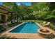 Inviting pool area featuring a waterfall feature, lounge chairs, and a cozy fire pit, perfect for relaxation and outdoor gatherings at 7906 Skye Lochs Dr, Waxhaw, NC 28173