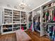 Spacious walk-in closet with custom shelving, drawers and an animal print bench seat; illuminated by a decorative chandelier at 7906 Skye Lochs Dr, Waxhaw, NC 28173