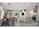 Open concept kitchen and dining area with a large island, stainless steel appliances, and views of the backyard at 808 Garringer Pl, Charlotte, NC 28208