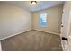 Carpeted bedroom features a single window and light-colored walls at 8809 Reedy Creek Rd, Charlotte, NC 28215