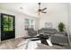 Bright living room with vaulted ceilings, fan, grey furnishings, and a black and white rug at 8809 Reedy Creek Rd, Charlotte, NC 28215