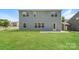 A lush backyard with a blue two-story home, a green lawn, and a blue sky at 9127 Colwick Hill Ln, Charlotte, NC 28215