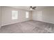 Spacious bedroom with two bright windows, ceiling fan, plush carpet and neutral walls at 9127 Colwick Hill Ln, Charlotte, NC 28215
