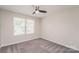 Bedroom with carpet floors, natural light from a large window, and modern ceiling fan at 9127 Colwick Hill Ln, Charlotte, NC 28215
