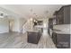 Open-concept kitchen featuring an island, dark cabinets, granite countertops, and wood floors at 9127 Colwick Hill Ln, Charlotte, NC 28215