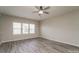 Bright living room with gray wood floors, a ceiling fan, and natural light from the windows at 9127 Colwick Hill Ln, Charlotte, NC 28215