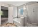 Bathroom featuring a soaking tub, glass enclosed shower, and tiled flooring at 9414 Seamill Rd, Charlotte, NC 28278