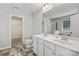 Bright bathroom featuring double sinks and a view into an adjacent walk-in closet at 9414 Seamill Rd, Charlotte, NC 28278