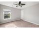 Bedroom with gray walls, ceiling fan, carpet, and a window at 9414 Seamill Rd, Charlotte, NC 28278