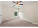 Neutral bedroom featuring a ceiling fan and a window offering a view of the outdoors at 9414 Seamill Rd, Charlotte, NC 28278