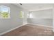 Bright bonus room with neutral walls, carpet, and natural light from three windows at 9414 Seamill Rd, Charlotte, NC 28278