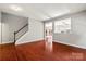 Open living room with hardwood floors, staircase, and clear view to the backyard at 9414 Seamill Rd, Charlotte, NC 28278