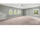 Large main bedroom featuring carpet, a ceiling fan and tray ceiling, and plenty of natural light at 9414 Seamill Rd, Charlotte, NC 28278