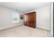 Carpeted bedroom with built in wooden closet and a window at 1006 Phil Oneil Dr, Charlotte, NC 28215