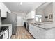 Bright kitchen features stainless steel appliances, granite countertops, white cabinetry, and wood floors at 1006 Phil Oneil Dr, Charlotte, NC 28215