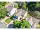 A bright aerial view of a home, with a well-manicured lawn, mature trees, and a neatly maintained roof at 10330 Seedling Ln, Charlotte, NC 28214