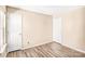 A simple bedroom featuring neutral walls, wood-look flooring, and two white doors at 10330 Seedling Ln, Charlotte, NC 28214