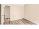 A simple bedroom featuring neutral walls, wood-look flooring, and a door at 10330 Seedling Ln, Charlotte, NC 28214