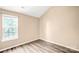 A bright bedroom featuring neutral walls, wood-look flooring, and a window at 10330 Seedling Ln, Charlotte, NC 28214