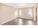 Empty dining room with hardwood floors, chandelier, and windows offering plenty of natural light at 10330 Seedling Ln, Charlotte, NC 28214