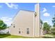 A two-story home with tan siding, a deck, a chimney, a green lawn, and a blue sky at 10330 Seedling Ln, Charlotte, NC 28214