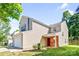 View of charming house with a two-car garage, red brick entrance, and green front yard at 10330 Seedling Ln, Charlotte, NC 28214