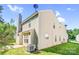 A bright beige two-story house featuring well-maintained siding, a chimney, and a neatly kept lawn at 10330 Seedling Ln, Charlotte, NC 28214