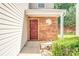 A close-up of the front door with brick accents and a small round window at 10330 Seedling Ln, Charlotte, NC 28214