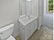 Bathroom featuring a white vanity, a large mirror, and neutral tile flooring at 1043 Park West Dr, Charlotte, NC 28209