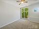 Bright bedroom with a large window offering a view of green trees, and neutral carpeting at 1043 Park West Dr, Charlotte, NC 28209
