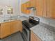 Modern kitchen features granite counters, stainless steel oven, wood cabinets, and dark tile floor at 1043 Park West Dr, Charlotte, NC 28209