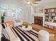 Bright living room featuring a fireplace, modern furnishings, and beautiful hardwood floors at 1043 Park West Dr, Charlotte, NC 28209