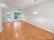 Bright living room with hardwood floors, ceiling fan, and sliding glass door to backyard at 1043 Park West Dr, Charlotte, NC 28209