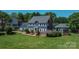 Charming two-story home with blue siding, white trim, brick chimney, and mature landscaping at 106 Chatworth Ln, Mooresville, NC 28117