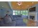 Bright living room with a fireplace, large windows, and a vaulted wooden ceiling with exposed beams at 106 Chatworth Ln, Mooresville, NC 28117