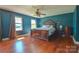 Spacious bedroom features a ceiling fan, hardwood floors, and a large bed with nightstands on both sides at 106 Chatworth Ln, Mooresville, NC 28117