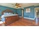 This main bedroom features a decorative wooden bed frame, hardwood floors, and a ceiling fan at 106 Chatworth Ln, Mooresville, NC 28117