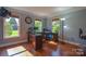 Well-lit home office with hardwood floors, two desks, and multiple windows at 106 Chatworth Ln, Mooresville, NC 28117