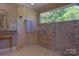 The shower features stylish stone walls, a built-in window, and modern fixtures at 106 Chatworth Ln, Mooresville, NC 28117