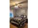 Comfortable bedroom featuring a plaid comforter, ceiling fan, and soft natural light at 10624 Wood Meadow Dr, Charlotte, NC 28227