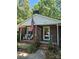 Welcoming covered front porch with chairs and brick facade with an American flag at 10624 Wood Meadow Dr, Charlotte, NC 28227