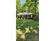 Charming brick home with an American flag, manicured lawn, and mature trees at 10624 Wood Meadow Dr, Charlotte, NC 28227