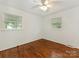 This bright, cozy bedroom features gleaming hardwood floors and large windows at 1100 Clawson Ct, Charlotte, NC 28209