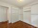 Walk-in closet with hardwood floors and built-in shelving and hanging storage at 1100 Clawson Ct, Charlotte, NC 28209