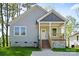 Inviting single-story home featuring a cozy front porch with gray siding and well-manicured lawn at 1101 Kenly St, Salisbury, NC 28144