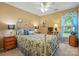 Tan bedroom featuring a patterned bed with matching pillows and furniture and a ceiling fan at 118 Winborne Dr, Mooresville, NC 28115
