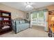 Bright bedroom with a decorative metal frame daybed, a ceiling fan, and a view of the yard at 118 Winborne Dr, Mooresville, NC 28115